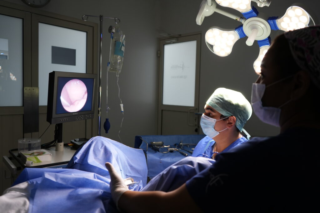 Histeroscopía médica: cirujano observa una pantalla con la imagen endoscópica del interior del útero durante un procedimiento diagnóstico o quirúrgico.