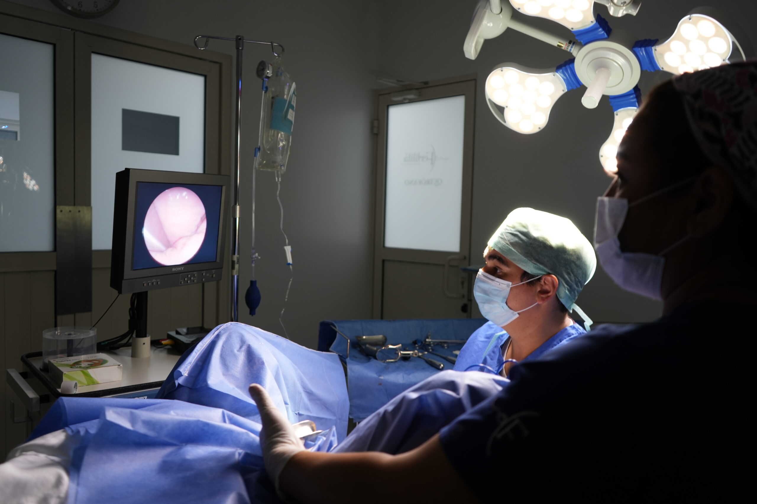 Histeroscopía médica: cirujano observa una pantalla con la imagen endoscópica del interior del útero durante un procedimiento diagnóstico o quirúrgico.